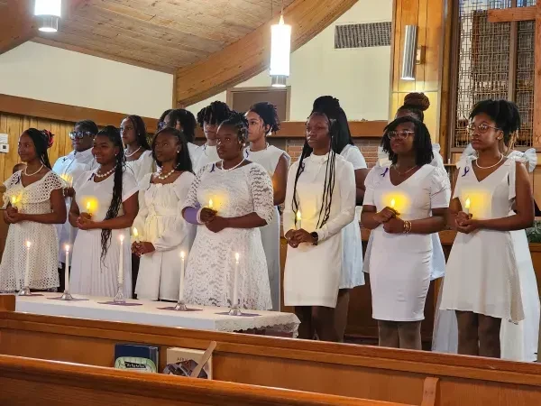 2024 Helen Sheffield Membership Induction — members in white dresses with candles in church